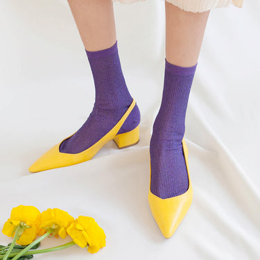 Purple socks with yellow shoes on a white background